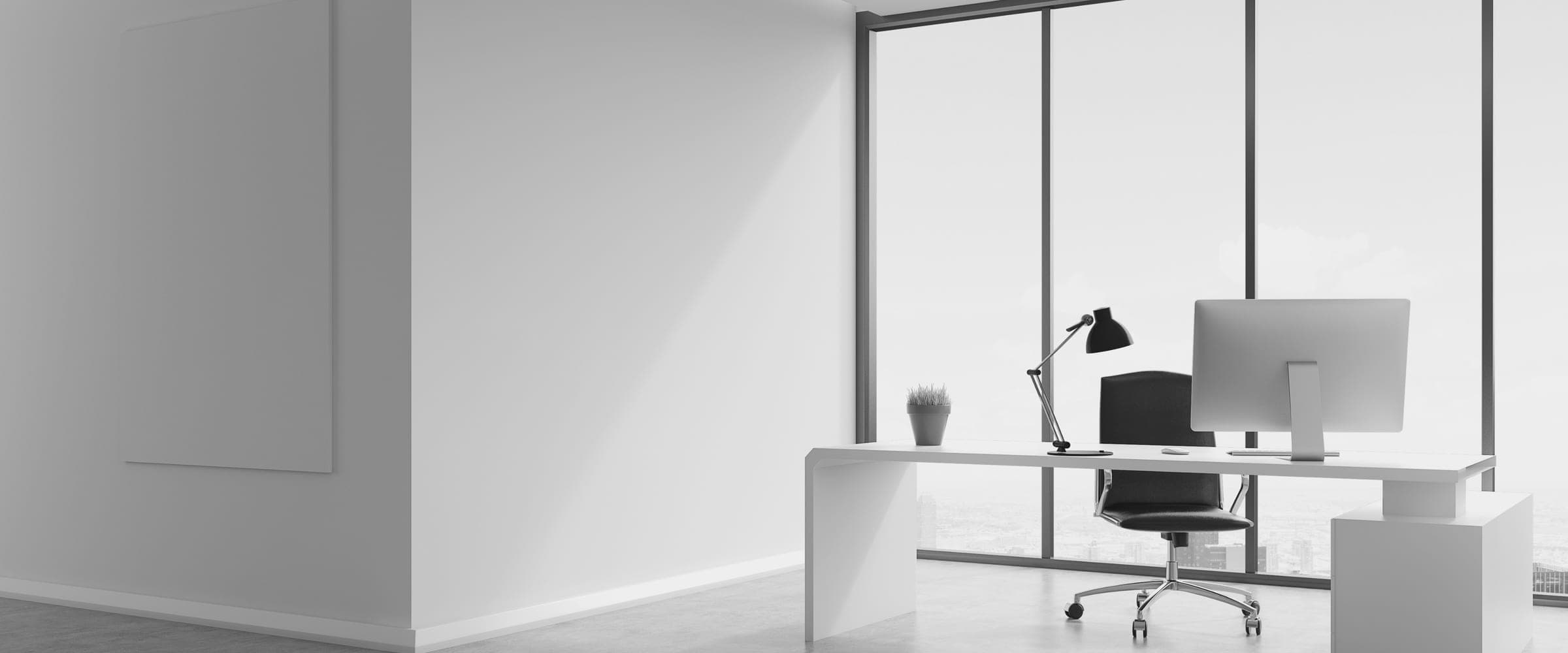 A focused, monochrome workspace — desk, screen and keyboard
